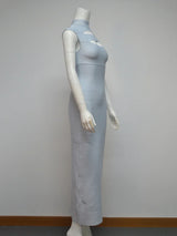 Side view of a light blue sleeveless bodycon maxi dress with cut-out detail at the bust and high neckline displayed on a mannequin against a white background.