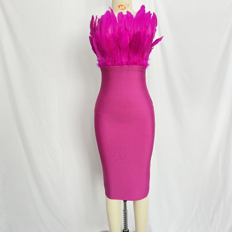 A rust-colored strapless bodycon dress with feather embellishment on the bust