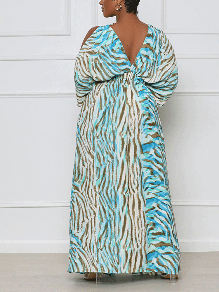 Woman wearing a blue and brown animal print maxi dress with a V-neck and cold-shoulder sleeves, standing and showing the back of the dress.