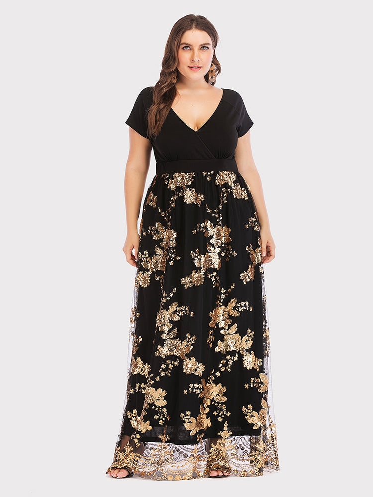 Plus-size model wearing a black maxi dress with gold sequined floral embellishments and a V-neck