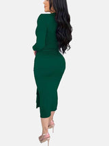 Rear view of a woman wearing a long-sleeved green ruched dress with a slit hem.