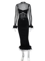 Black velvet midi dress with sheer sleeves and feather trim on a mannequin