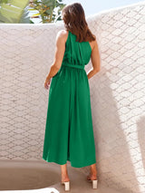 Back view of a woman wearing a green one-shoulder midi dress with a belted waist.