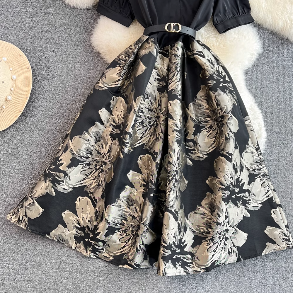 Full view of a black and floral print midi dress laid flat