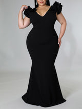 Side view of a plus-size model wearing a black mermaid dress.