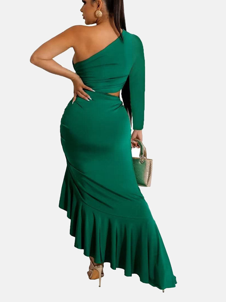 Back view of a woman in a green one-shoulder, long-sleeved maxi dress with a cut-out waist and ruffled asymmetrical hem.