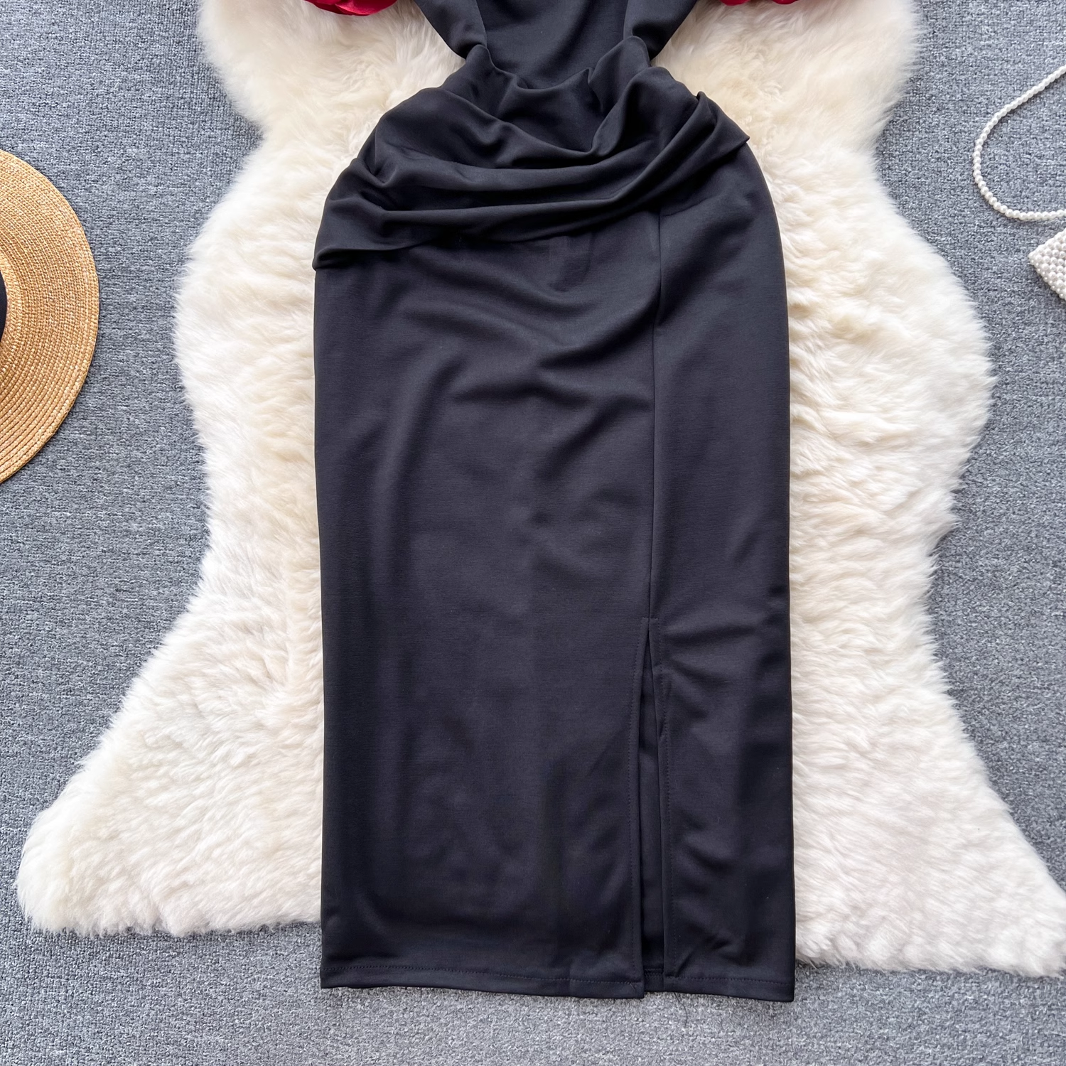 Detail of the ruched skirt and slit on the black dress