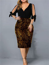 Woman wearing a black and gold sequined sheath dress with cold shoulder sleeves and pearl accents