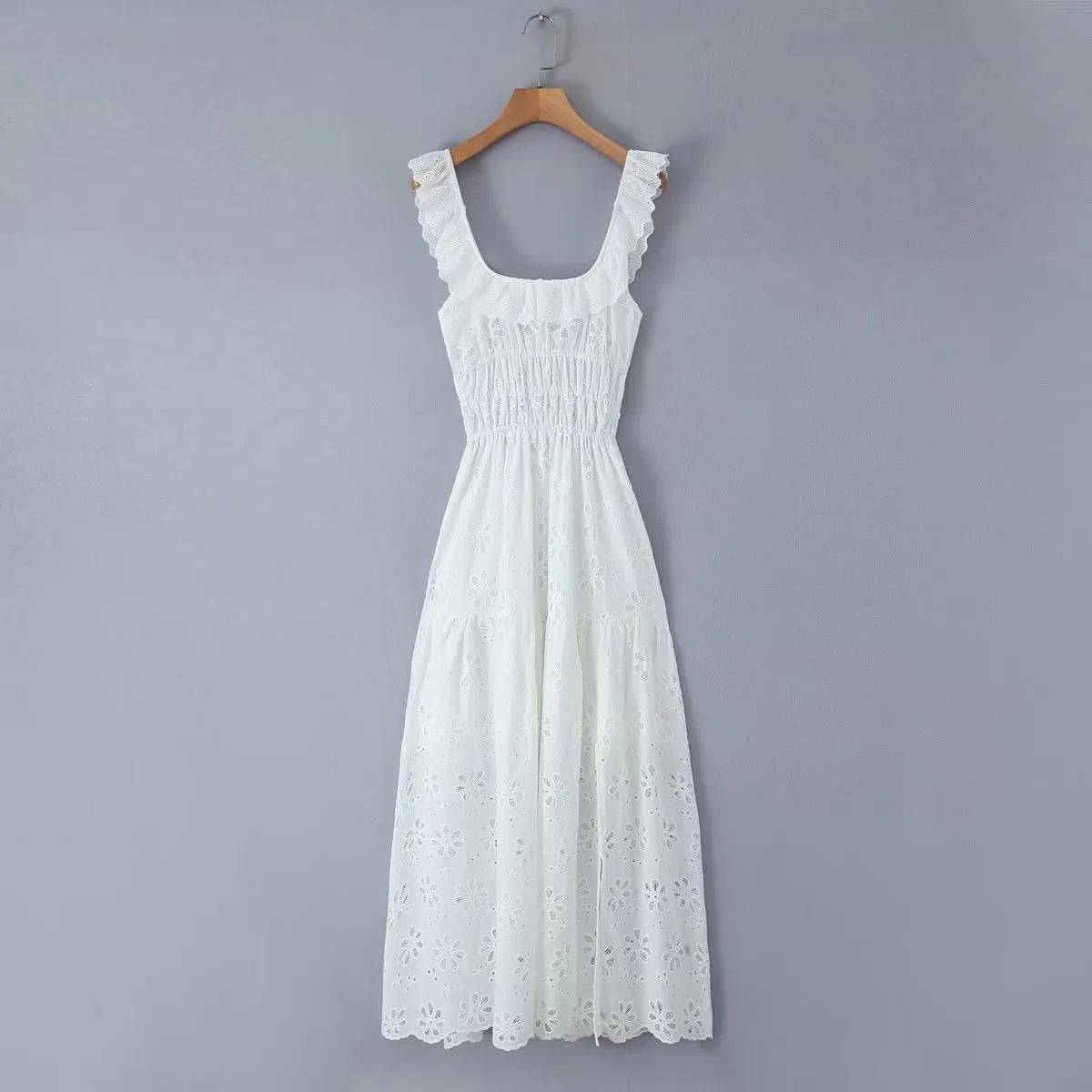 White eyelet maxi dress hanging on a wooden hanger against a grey background