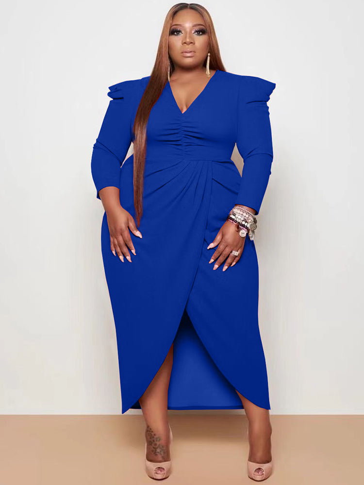 Woman wearing a royal blue ruched V-neck sheath dress with an asymmetrical tulip hem and puffed shoulders.