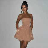 Woman wearing a nude strapless glitter mini dress with a flared skirt, with added sparkle effect.