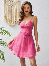 Close-up of a woman in a pink cami dress with a ruffled v-neck.