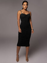 Full-length view of a woman in a black ruched sparkly knit midi dress.