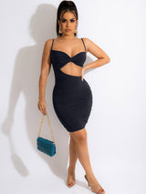 Woman wearing a black ruched bodycon dress with a cut-out detail and twisted bust.