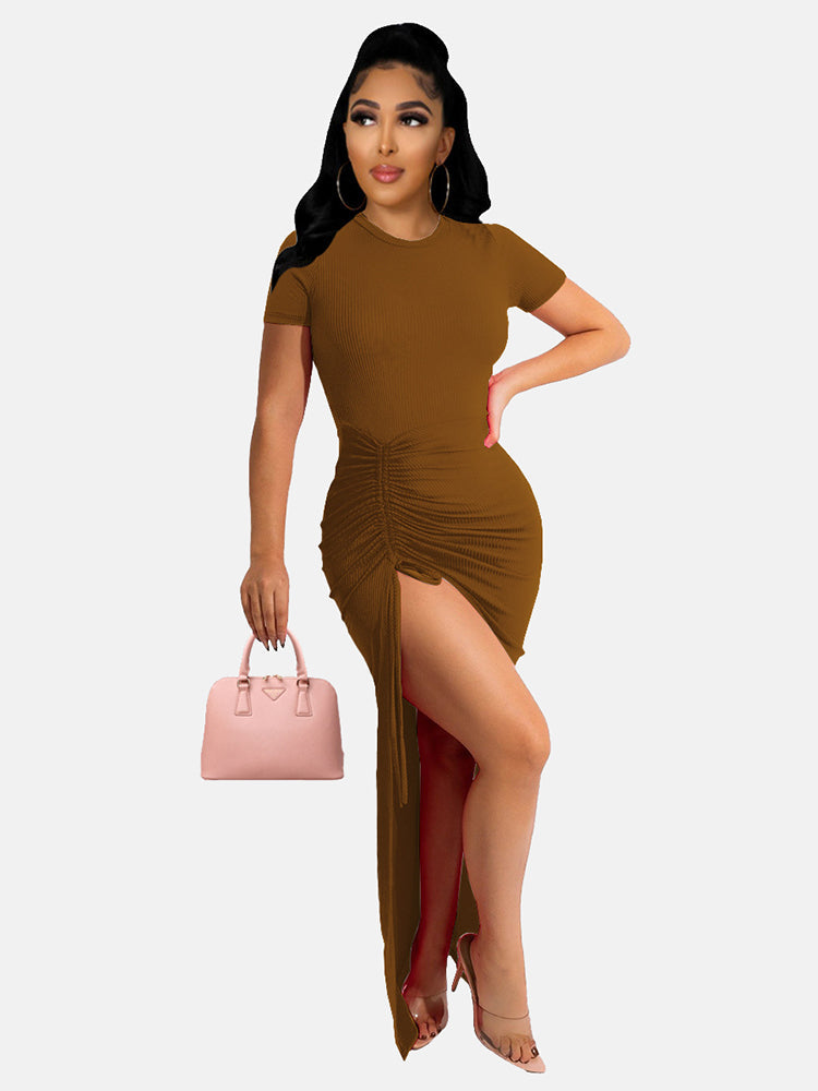 Woman in a brown ruched maxi dress with a high slit