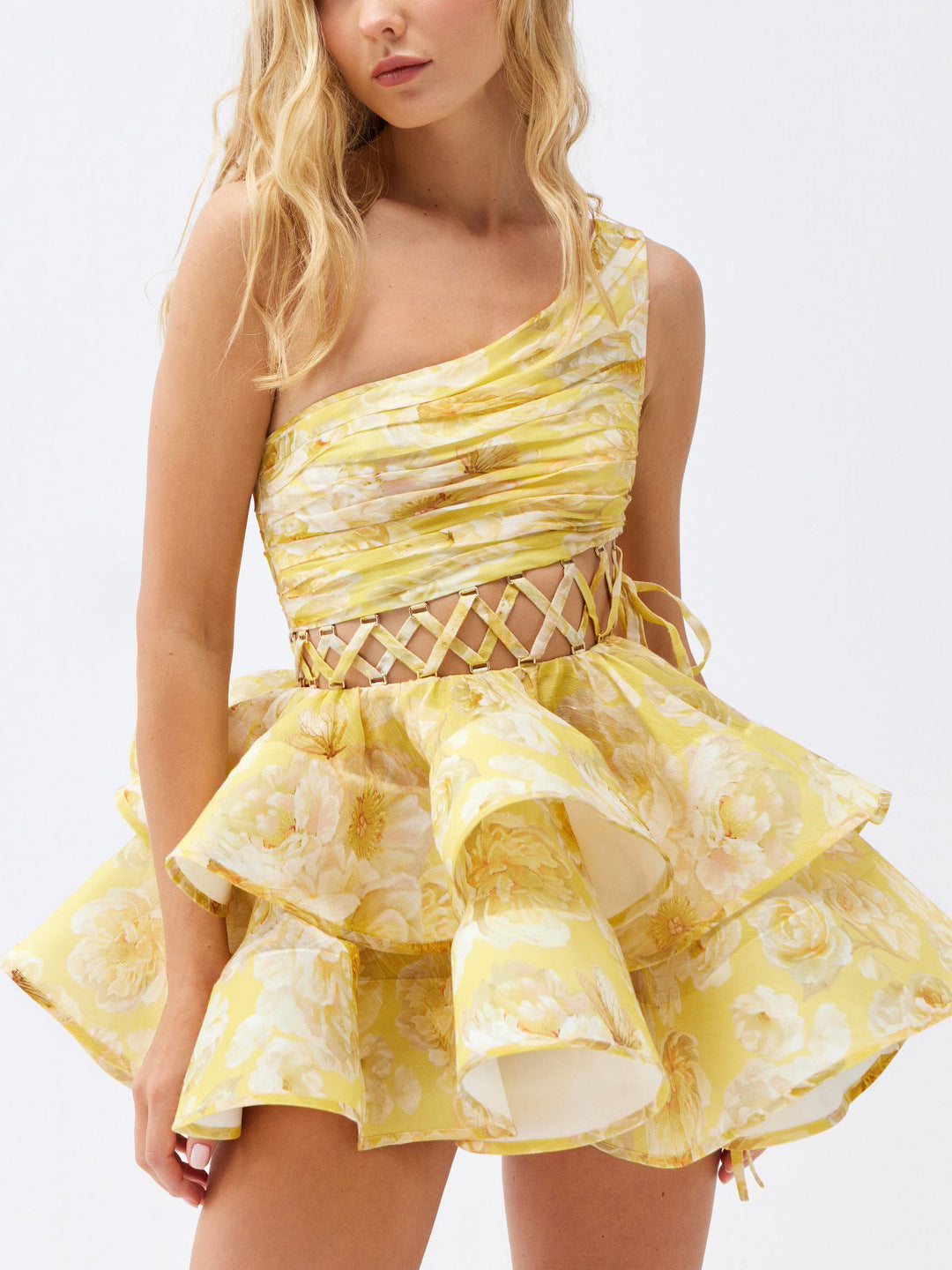 Close-up of a yellow floral print one-shoulder mini dress with a ruffled skirt.