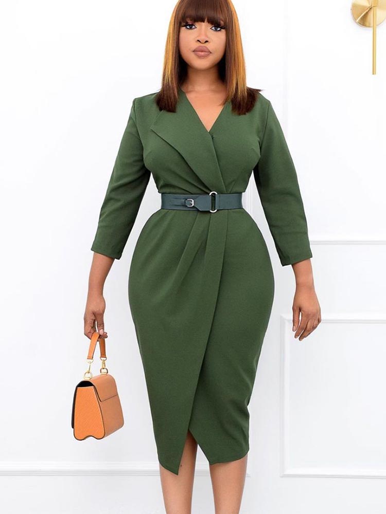 Woman wearing a green wrap dress with a notched lapel and belted waist