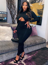 Full-length view of a woman wearing a black knit maxi dress with a cutout.