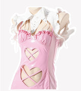 Close-up of pink patent mini dress bodice with harness detail, cut-outs, bows, and ruffled collar.