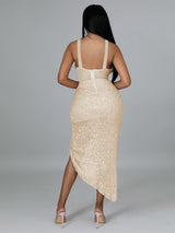 Back view of a woman in a gold sequined halter neck dress.