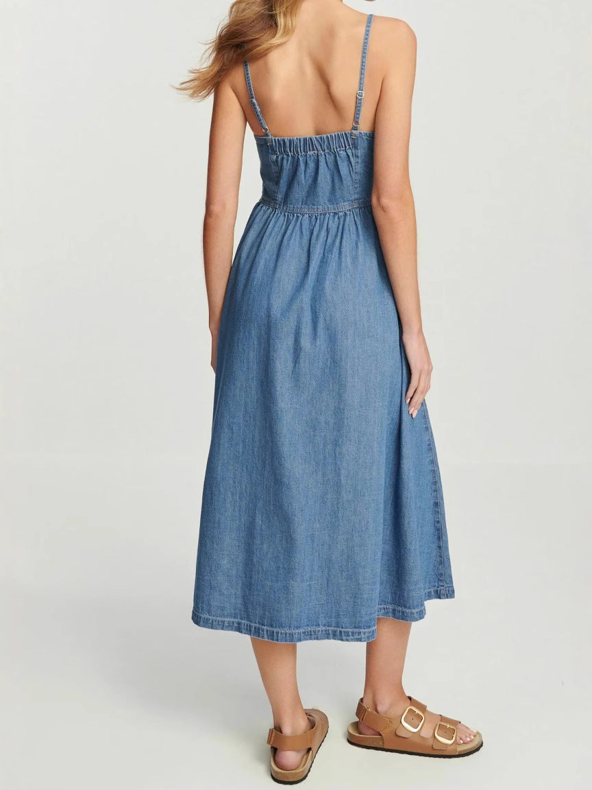 back view of a woman in a blue denim midi dress with spaghetti straps