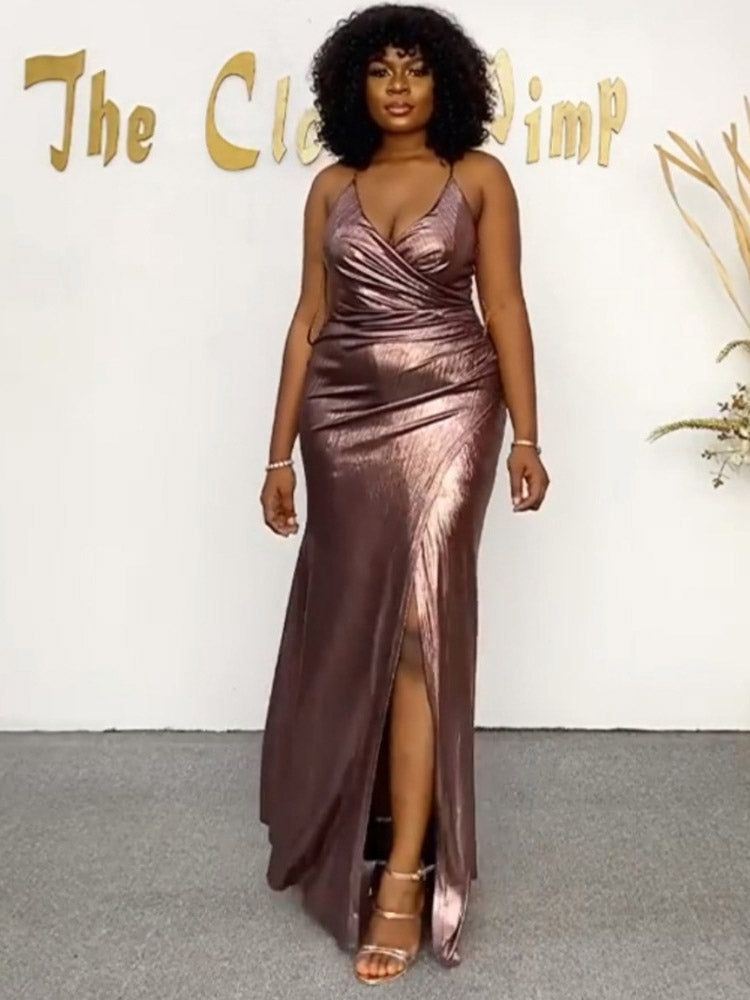 A woman in a metallic rose gold evening gown with a high slit.