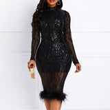Front view of a woman in a black sequin dress with a mock neck and feather hem.