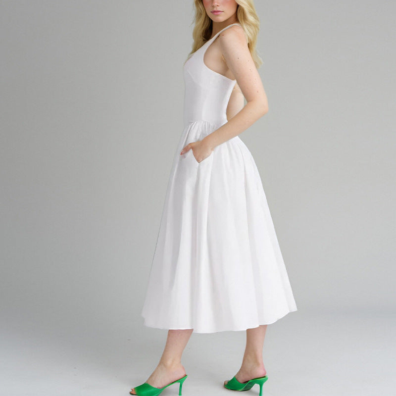 Woman in a white halter dress with pockets, showing the side view.
