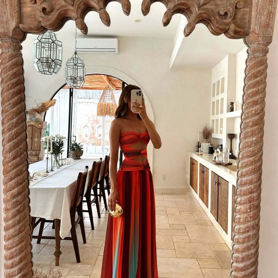 Woman in a vibrant ombre maxi dress posing for a mirror selfie