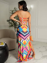 back view of a woman in a colorful geometric print strapless maxi dress with cut-out details
