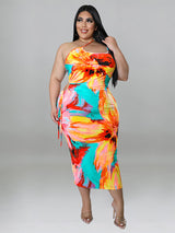 Plus-size woman wearing a colorful floral print halter neck bodycon midi dress with cut-out details and a tie waist, front view