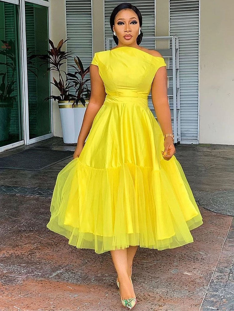 woman in yellow off-the-shoulder midi dress with tulle overlay