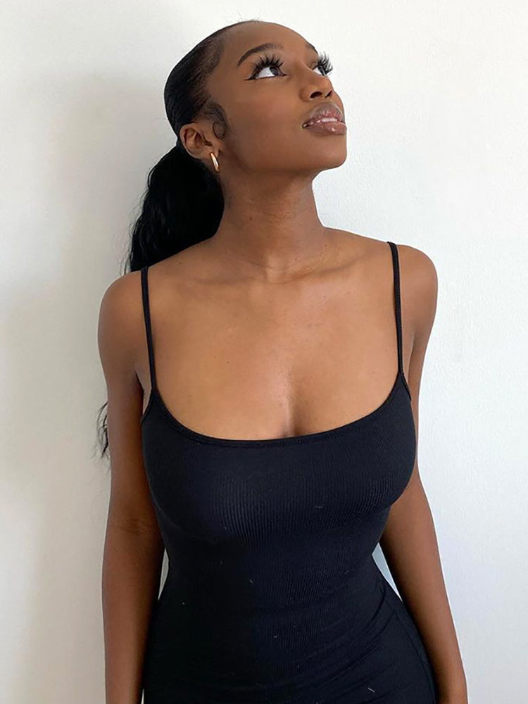 Close-up of a woman's upper body in a black ribbed knit maxi dress with spaghetti straps