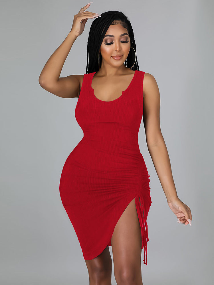 Woman wearing a red ruched bodycon dress with a drawstring hem and high slit