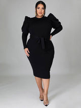 Model wearing a black midi dress with puff sleeves and a matching belt
