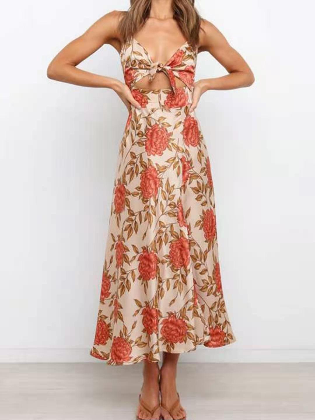 Woman posing in a floral print midi dress with a high slit.