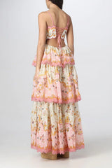 Back view of a woman in a floral print maxi dress with a lace-up back and tiered skirt