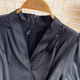 Close-up of the V-neckline and zipper on a black dress