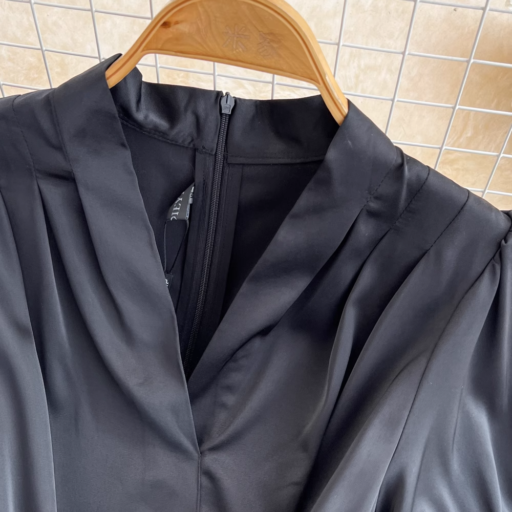 Close-up of the V-neckline and zipper on a black dress
