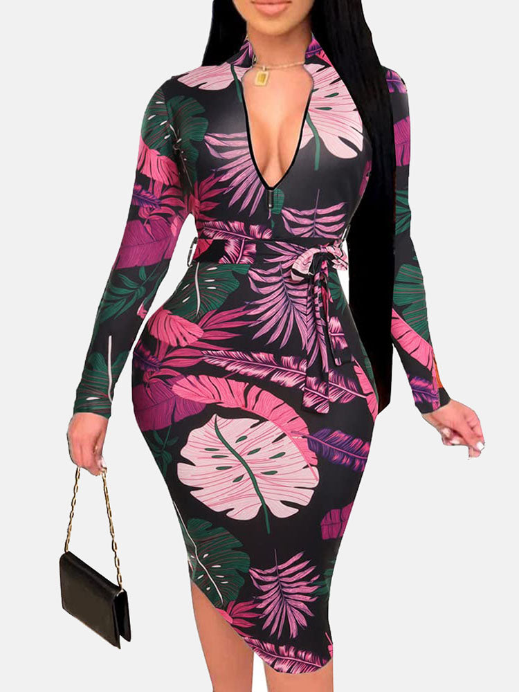 Woman in a black midi dress with a pink and purple leaf print, V-neck, long sleeves, and a belted waist.
