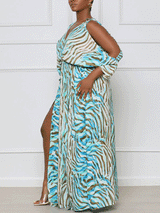 Woman wearing a blue and brown animal print maxi dress with a V-neck and cold-shoulder sleeves, standing in profile and showing the side of the dress.