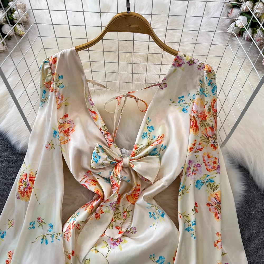 Close-up of the V-neckline and bow detail on a floral print satin dress.