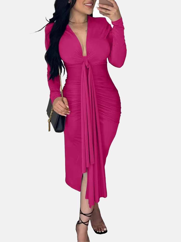 Woman wearing a long-sleeved pink ruched dress with a tie-front detail and a slit hem, holding a black purse.