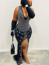 Full-length view of a woman wearing a black embellished mermaid gown with a thigh-high slit and matching gloves.
