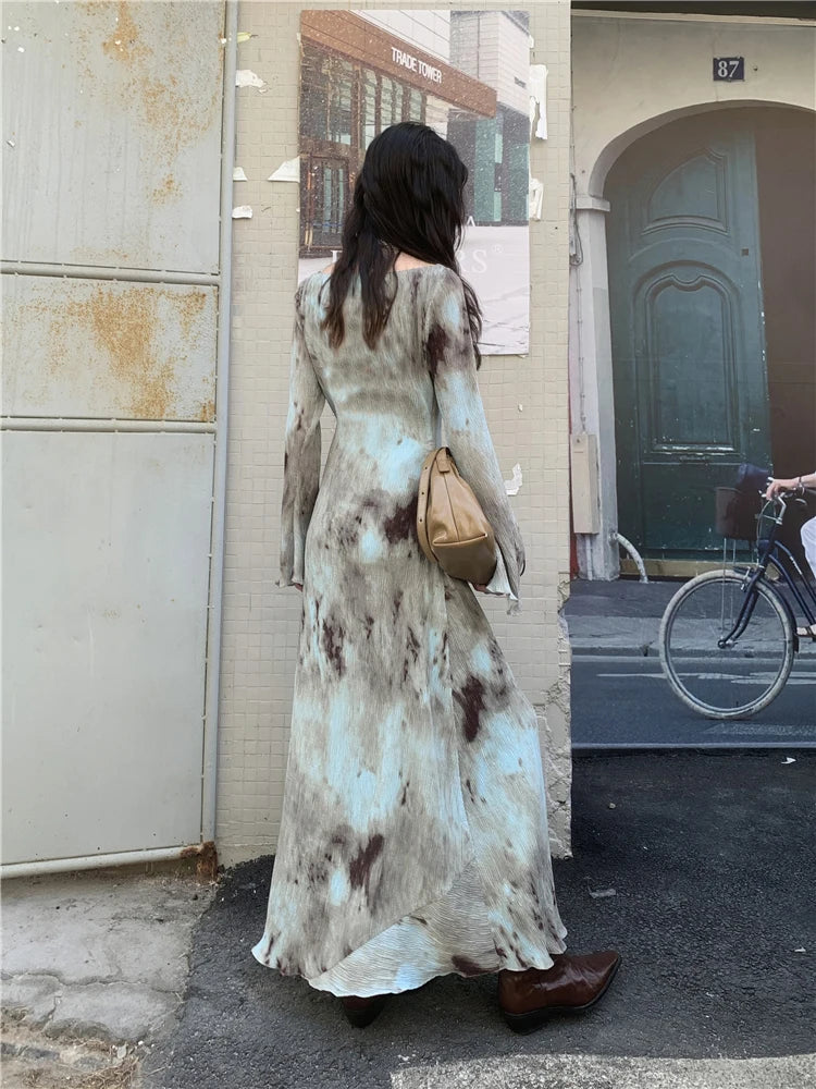 Back view of a woman in a tie-dye maxi dress, highlighting the length and the tie-dye pattern.