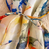 Detail shot of the tie belt on a flowing abstract floral print maxi dress.