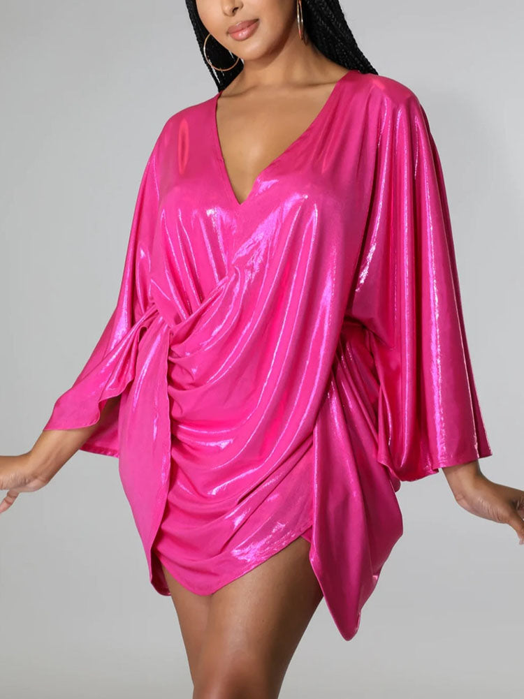 Model posing in a dazzling pink wrap dress with a deep V-neck.