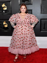Woman in strawberry print dress posing