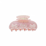 Pink hair claw clip with white 3D bows and rhinestones on a white background