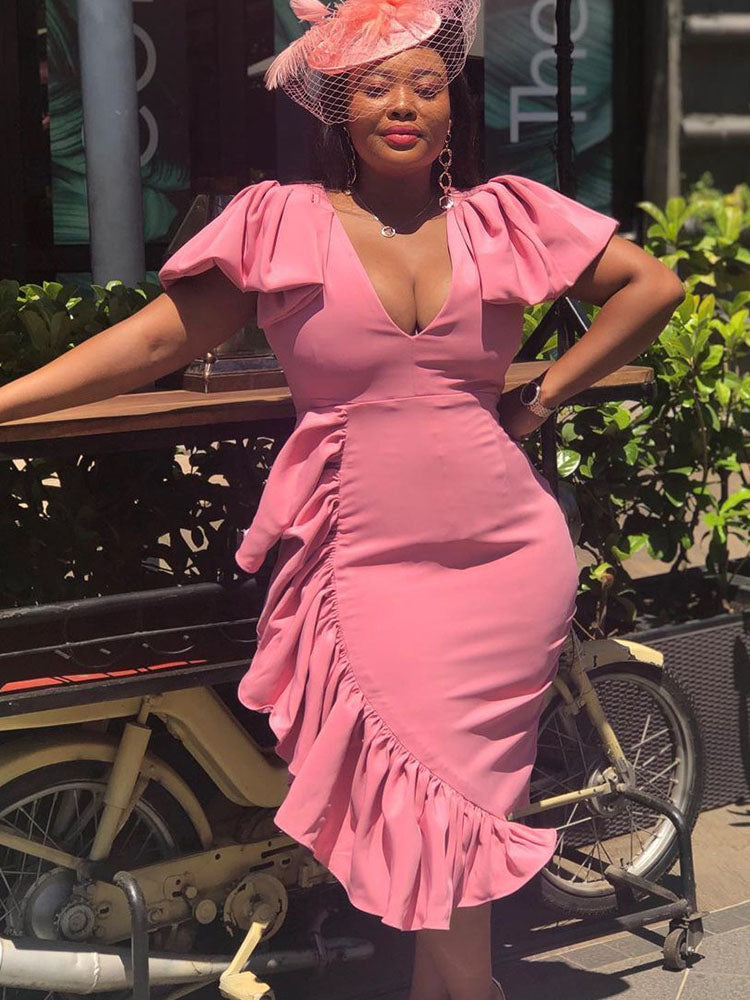 woman wearing a pink ruffled dress and a fascinator